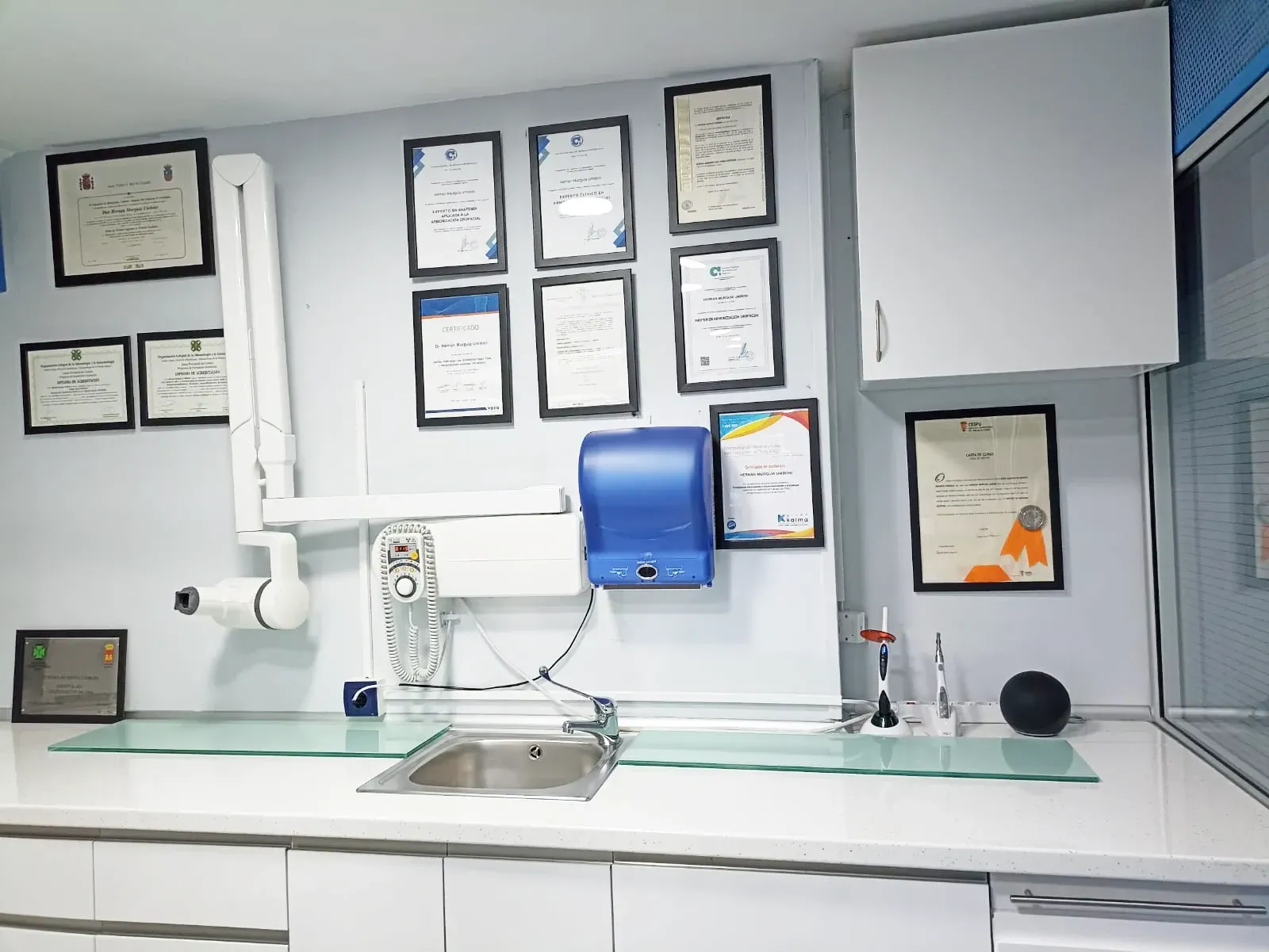 Una cocina con un fregadero y un dispensador de toallas de papel azul.